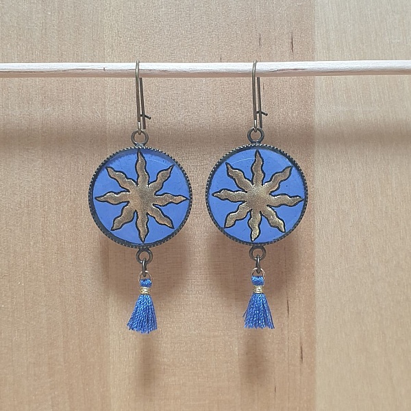 Boucles d'oreille pendantes soleil dor&eacute; sur fond bleu