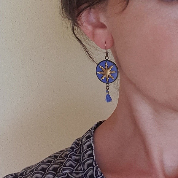 Boucles d'oreille pendantes soleil dor&eacute; sur fond bleu