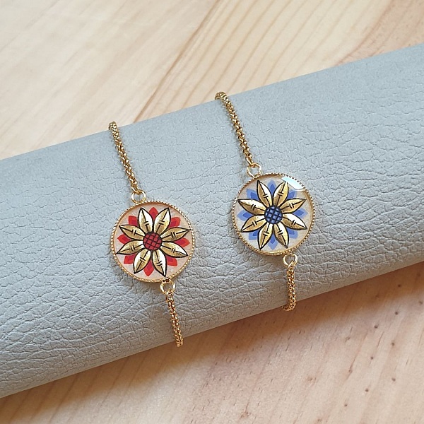 Justerbart armb&aring;nd med gull/bl&aring;tt blomstermotiv p&aring; gullkjede