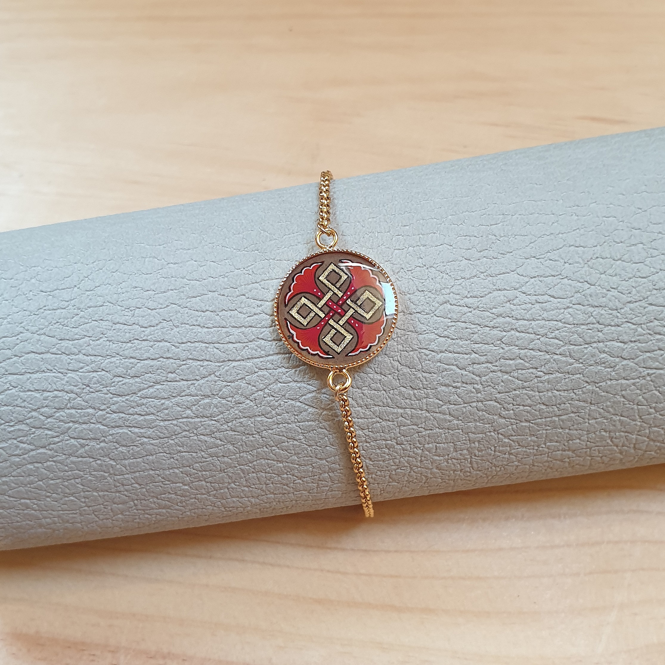 Bracelet r&eacute;glable entrelacs or et palmettes rouges ou bleues