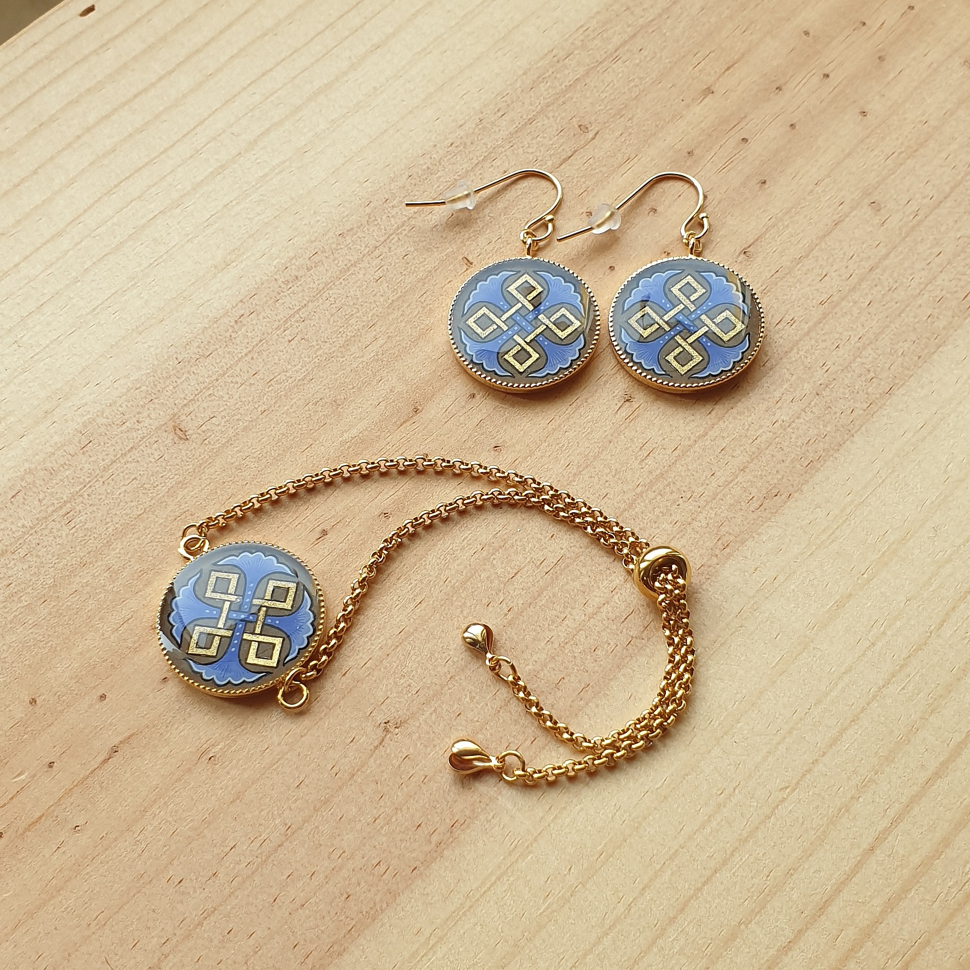 Bracelet r&eacute;glable entrelacs or et palmettes rouges ou bleues