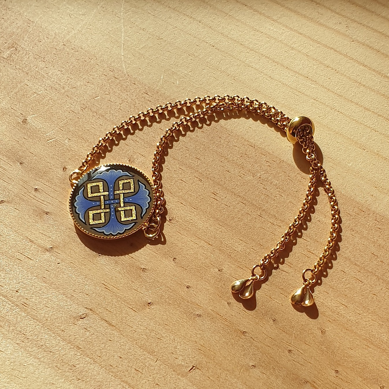 Bracelet r&eacute;glable entrelacs or et palmettes rouges ou bleues