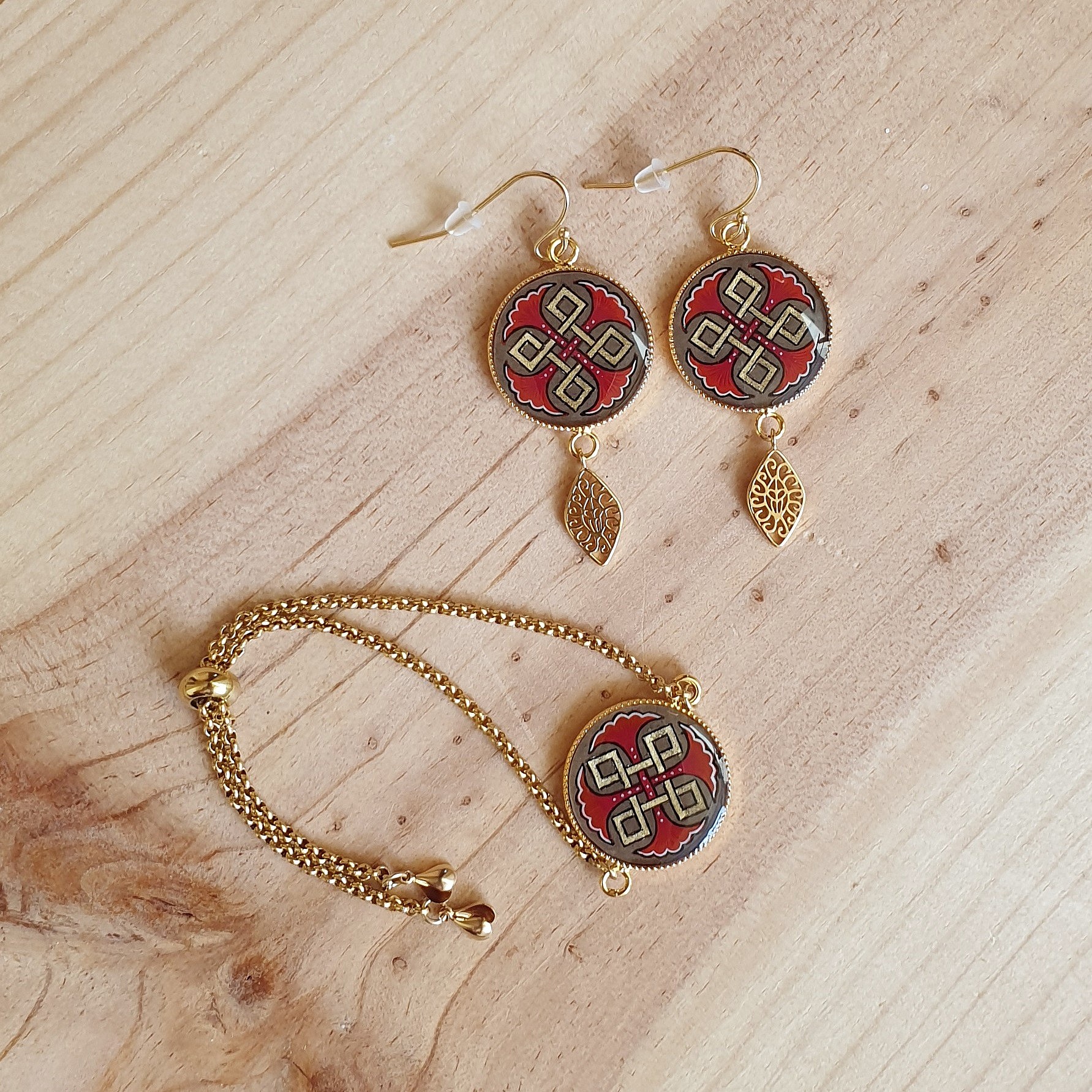 Bracelet r&eacute;glable entrelacs or et palmettes rouges ou bleues