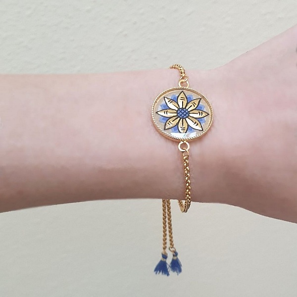 Justerbart armb&aring;nd med gull/bl&aring;tt blomstermotiv p&aring; gullkjede