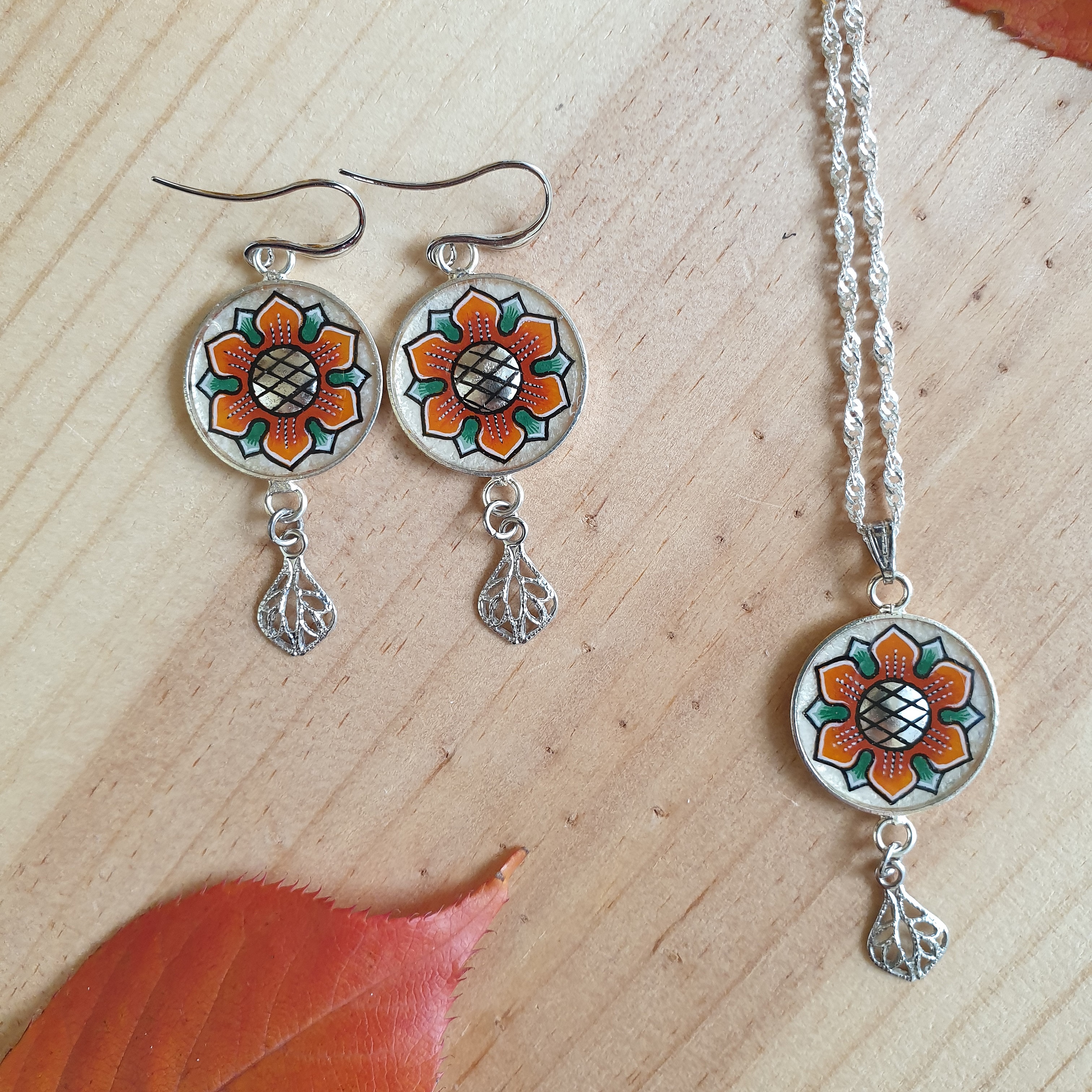 Halskjede med oransje/gull v&aring;rblomst anheng p&aring; s&oslash;lvkjede