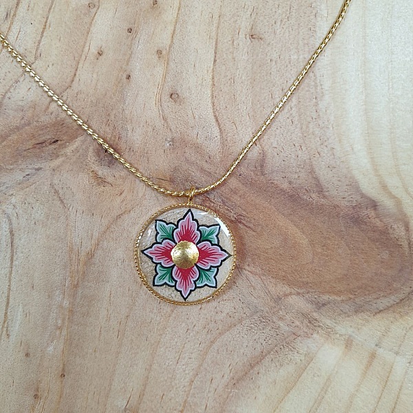 Halskjede med rosa eller bl&aring; blomster p&aring; gullkjede