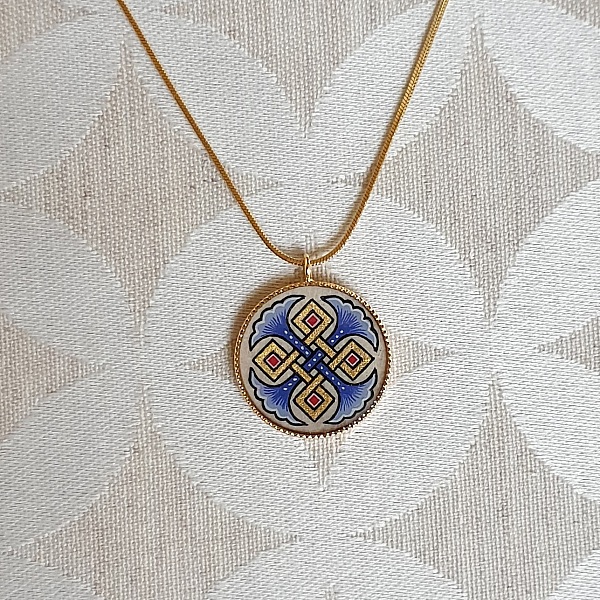 Halskjede med anheng med bl&aring; palmetter, gull og r&oslash;dt flettverk p&aring; gullkjede